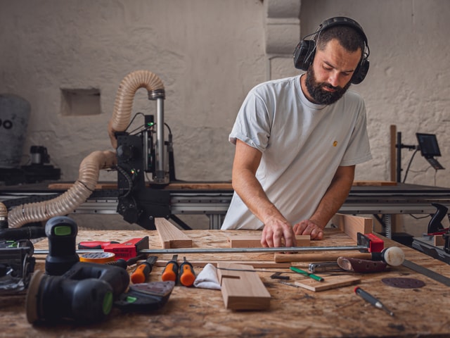 Haddock Menuiserie assembling a stool whit a Mekanika Fab is action in the background