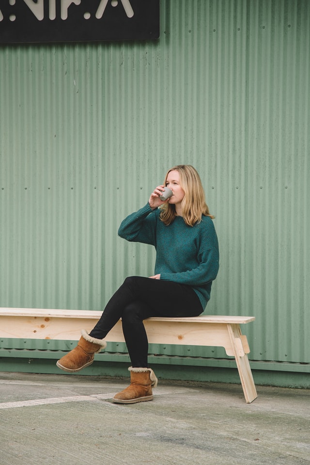 Delphine drinking a coffee on a bench made with the Mekanika Fab