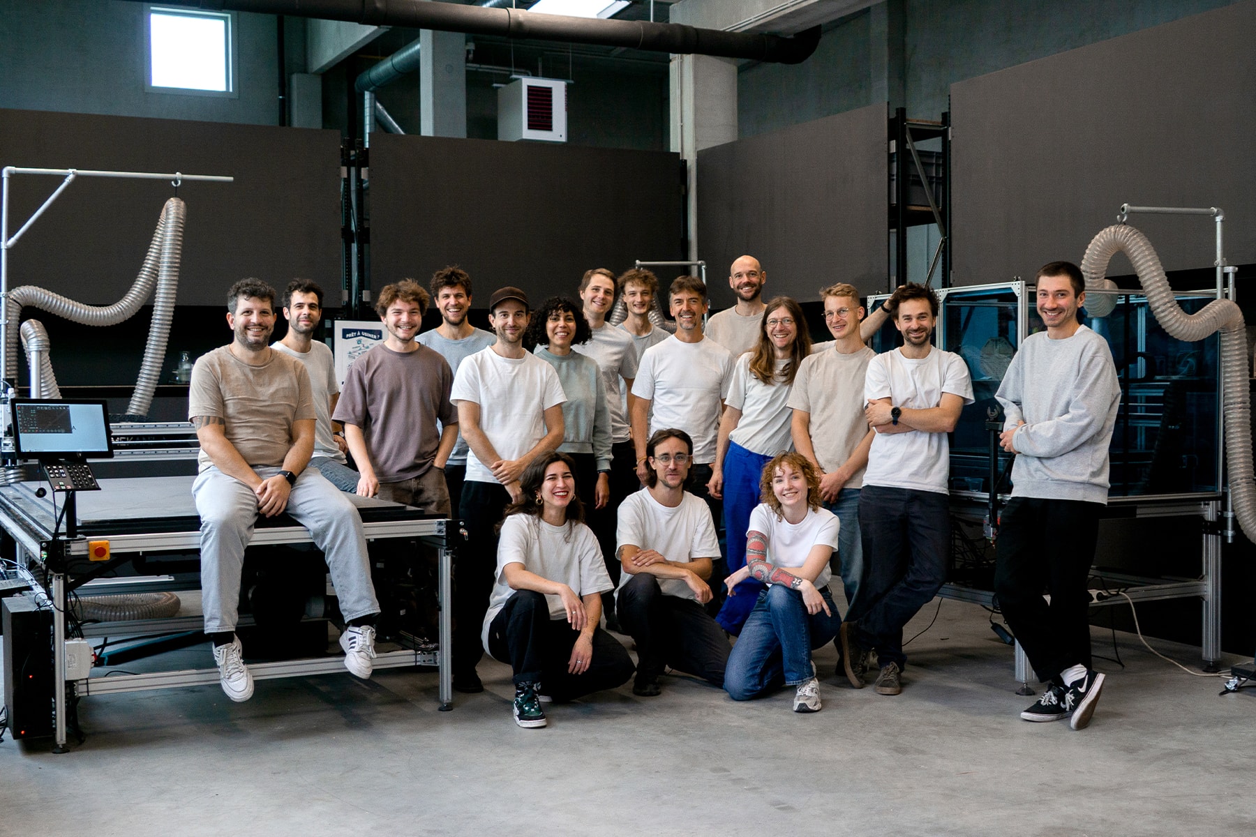 Mekanika team posing together next to CNC machines