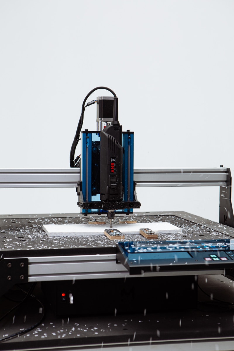 Mekanika Evo CNC milling machine close up while milling a plastic sheet